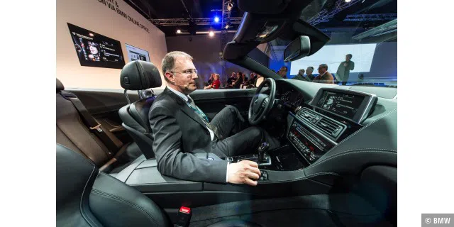 Ein BMW-Verantwortlicher führt Online-Entertainment in einem 6er Coupe vor.