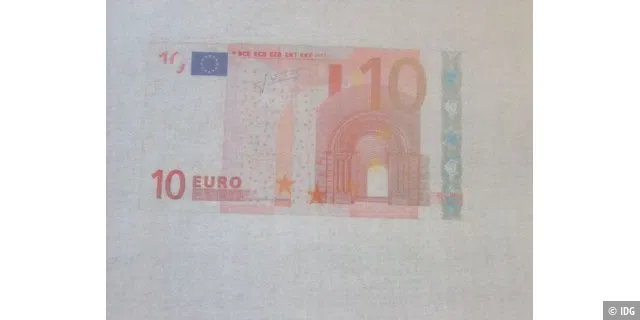 Kopierer unterlegt Banknotenkopie mit grauem Hintergrund