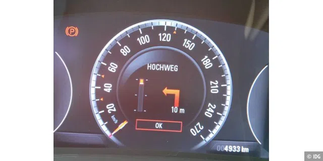 Driver Information Center mit eigenem Bildschirm im Cockpit vor dem Fahrer. In diesem Beispiel werden Abbiege-Hinweise angezeigt, es läuft also die Navigation.